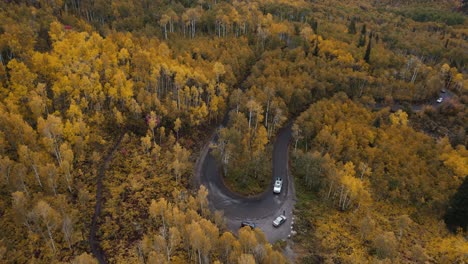 car drive on alpine loop serpentine road during yellow fall forest scenery