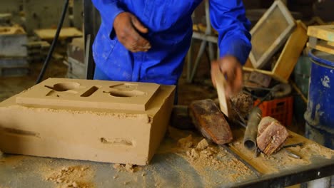 mid section of worker making mold in foundry workshop 4k