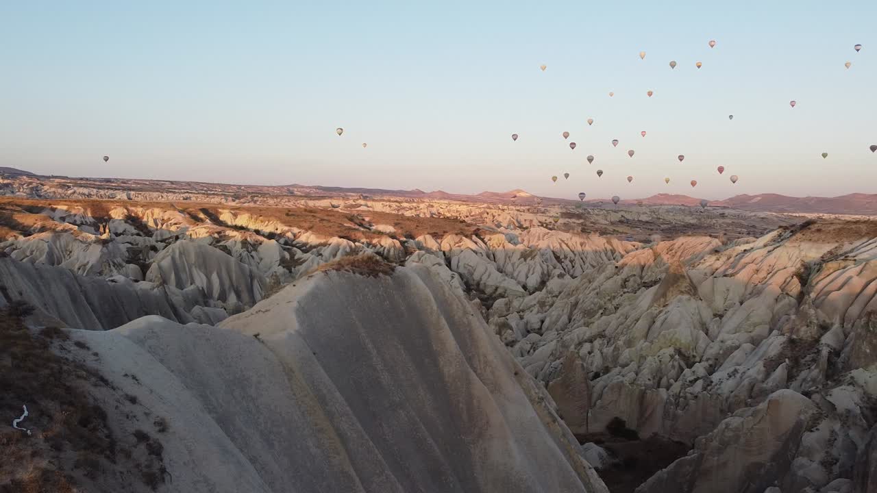 chica brunnette viendo el amanecer en capadocia bajo un cielo de globos de colores