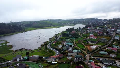 Flying-Over-Colonial-Houses-In-Nuwara-Eliya-Towards-Gregory-Marvelous-Lake-Where-People-Enjoy-Water-Activities,-Sri-Lanka