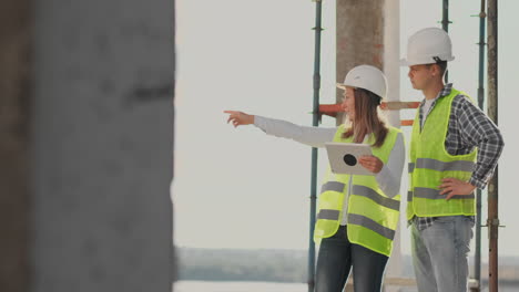 engineers or architects have a discussion at construction site looking through the plan of construction. contre jour. engineers or architects have a discussion