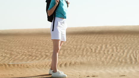 woman with sunglasses and backpack walking