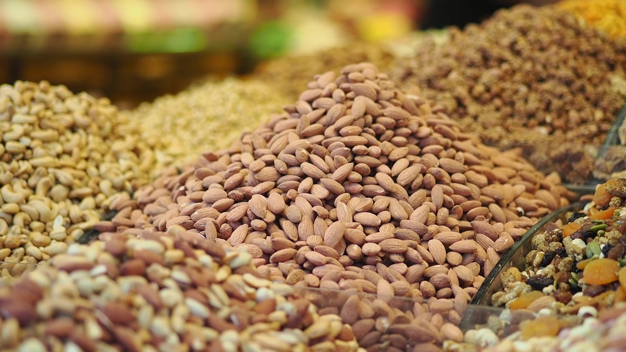 Assorted Piles of Raw Nuts and Dried Fruits at a Market Stall