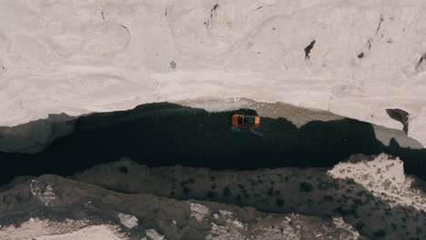 Todoterreno-Naranja-4x4-Conduciendo-En-El-Río-Del-Cañón,-Vista-Aérea-De-Arriba-Hacia-Abajo