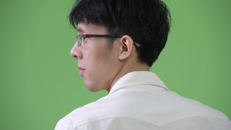 young curious asian businessman looking over the shoulder