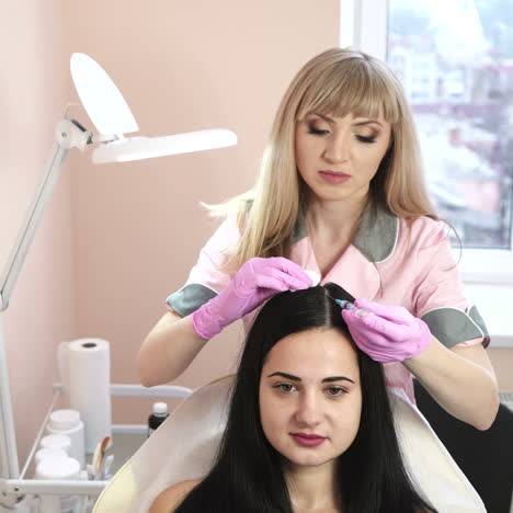 needle mesotherapy. cosmetologist makes injections in woman head. strengthen the hair and their growth