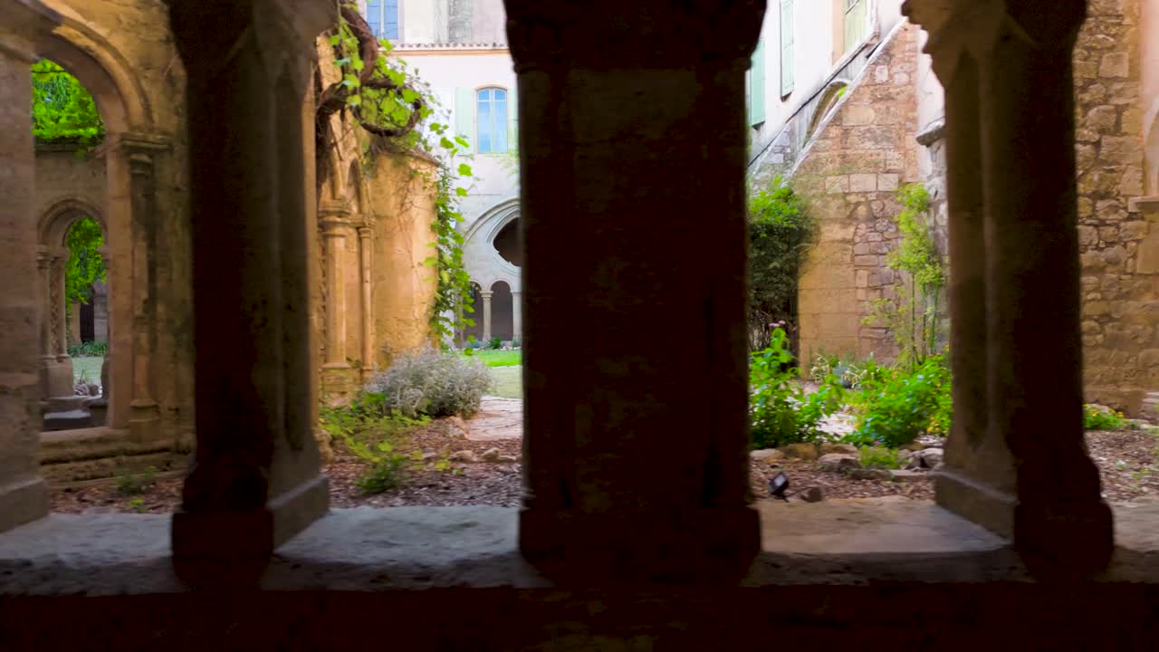 Slow motion dolly shot of archways revealing the beautiful garden courtyard