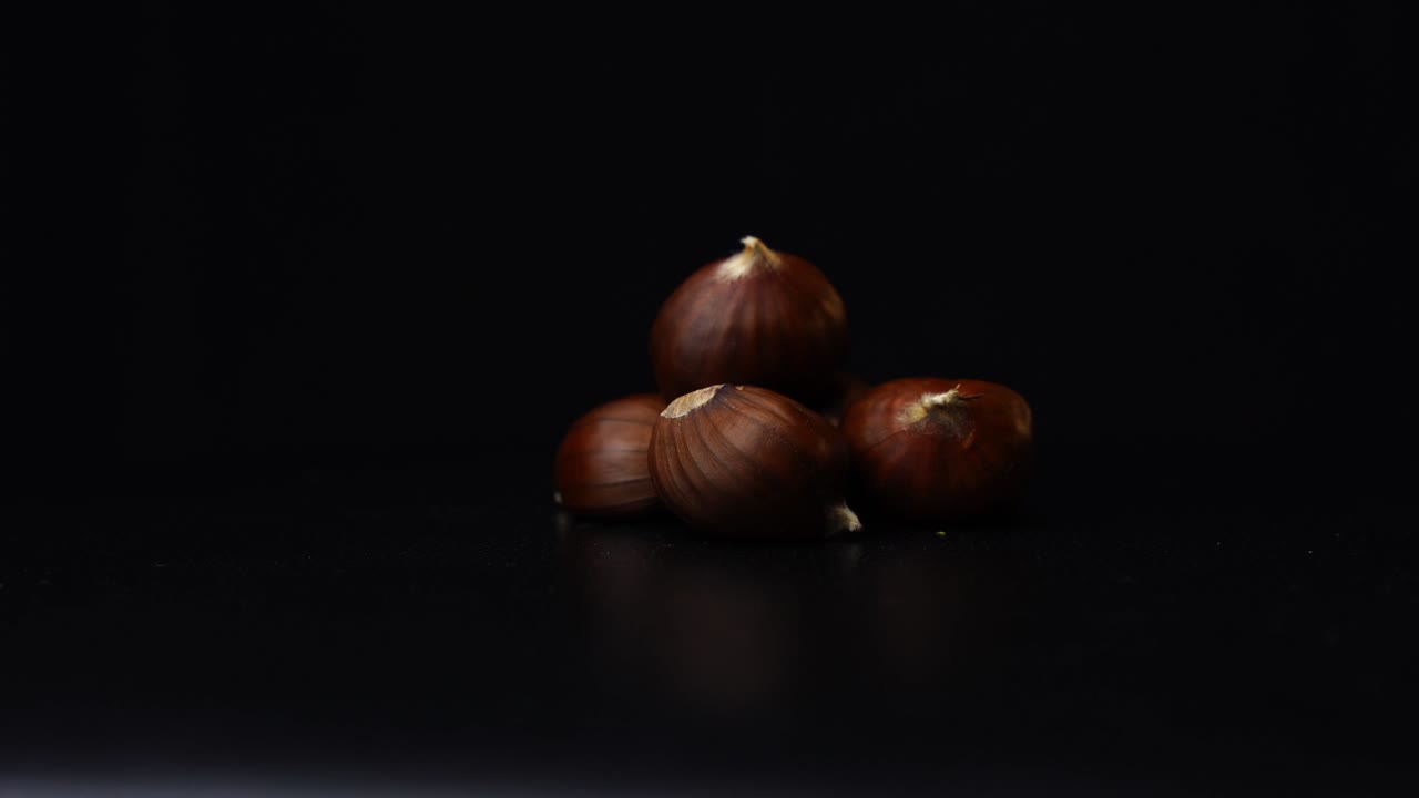 3 chestnuts rotating in front of a black background