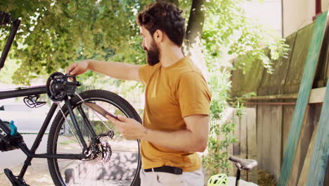 hombre manteniendo una bicicleta con una tableta