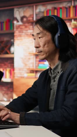 vertical video startup office chief technology officer listens music while coding application