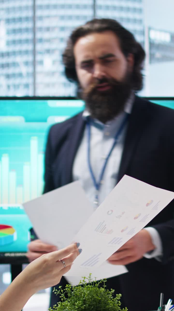Video verticale. Consulente finanziario che mostra grafici statistici su grande schermo ai clienti.