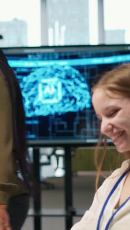 vertical video cheerful startup manager satisfied with progress of intern learning to use ai