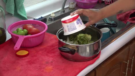 agregando especias a los nopales antes de hervir