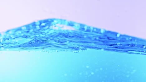 the clean water surface in slow motion fills the screen with water splashing shop the water drop and waving liquid surface with an air bubble