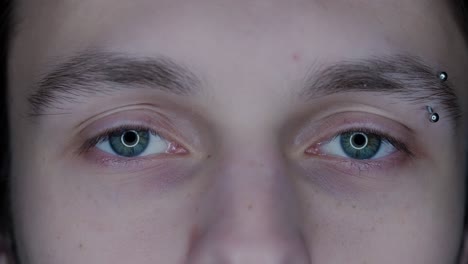 close-up of a person's face with eyebrow piercings