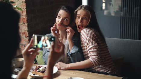 friends making faces at a cafe