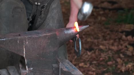 blacksmith forging heart shaped iron on anvil, closeup, nobody