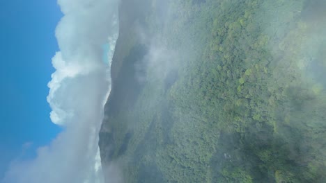 vuelo aéreo sobre las nubes con una amplia área de montañas con bosque denso de hoja perenne, parque nacional de chiang mai doi suthep, hábitat de especies de área protegida, vídeo de retrato vertical en 4k