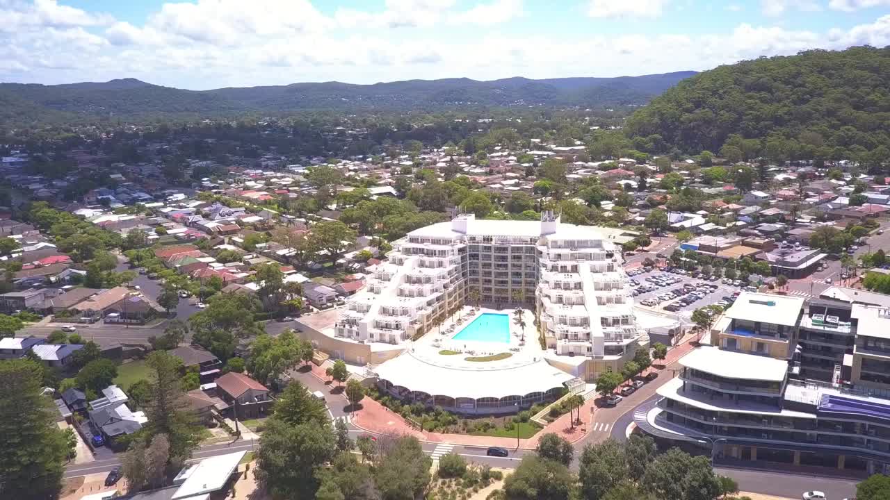 Forward fly over suburb of Sydney with white sand beach ocean view houses. Ettalong, Sydney Australia.