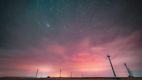 Un-Timelapse-Del-Hermoso-Cielo-Nocturno-Con-Nubes-Rosadas-Y-Un-Rastro-De-Estrellas-Brillantes