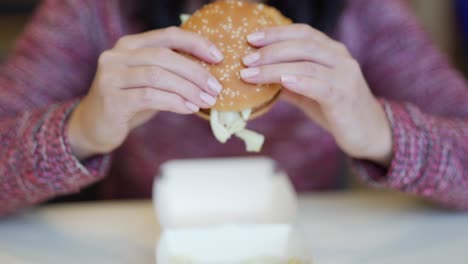 woman eating a burger at a restaurant