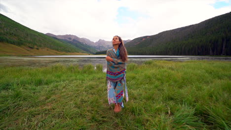 Cinematic-female-women-actress-model-walking-away-from-shoreline-grass-colorful-blanket-still-calm-Piney-River-Ranch-Lake-Denver-Vail-Gore-Range-scenic-mountain-landscape-peaceful-rain-sun-follow