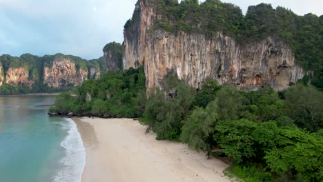 Playa-Railay-Krabi-Tailandia-Aérea-Sobre-El-Agua-Con-Acantilados-De-Piedra-Caliza,-Playa-Tonsai,-Amanecer---Sobrevuelo-Aéreo