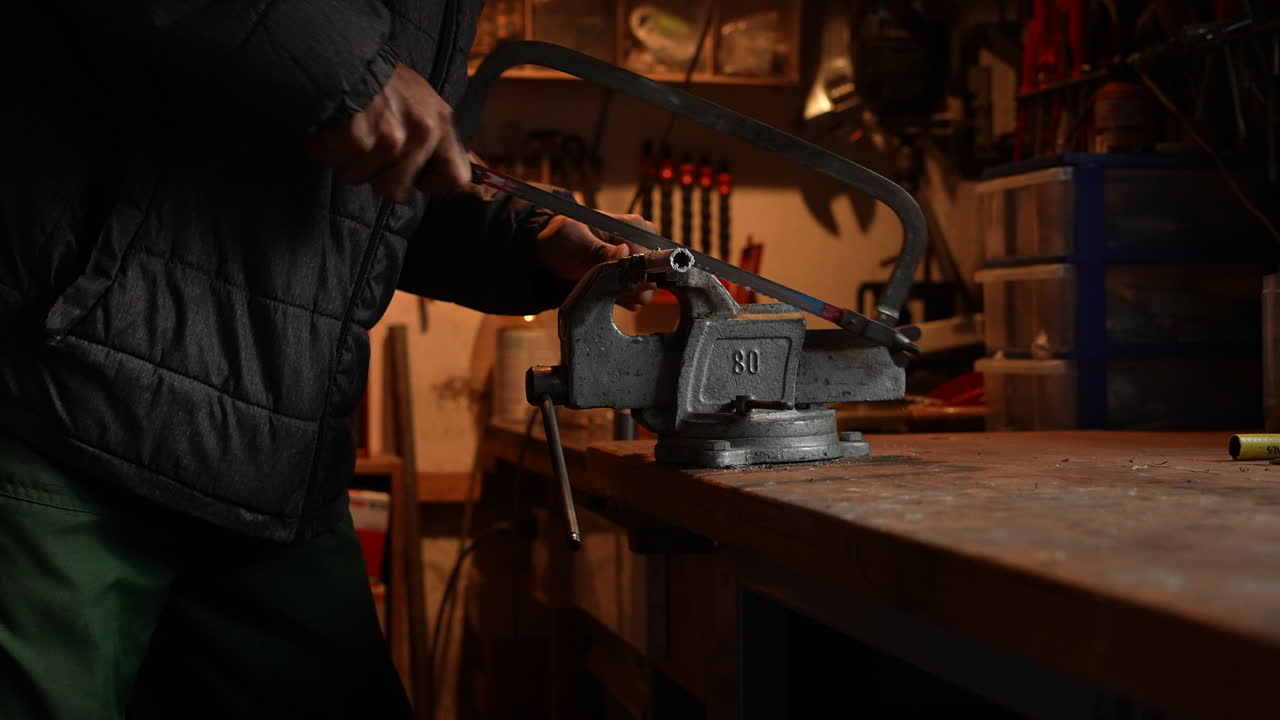hombre usando una sierra para metales, cortando un tubo