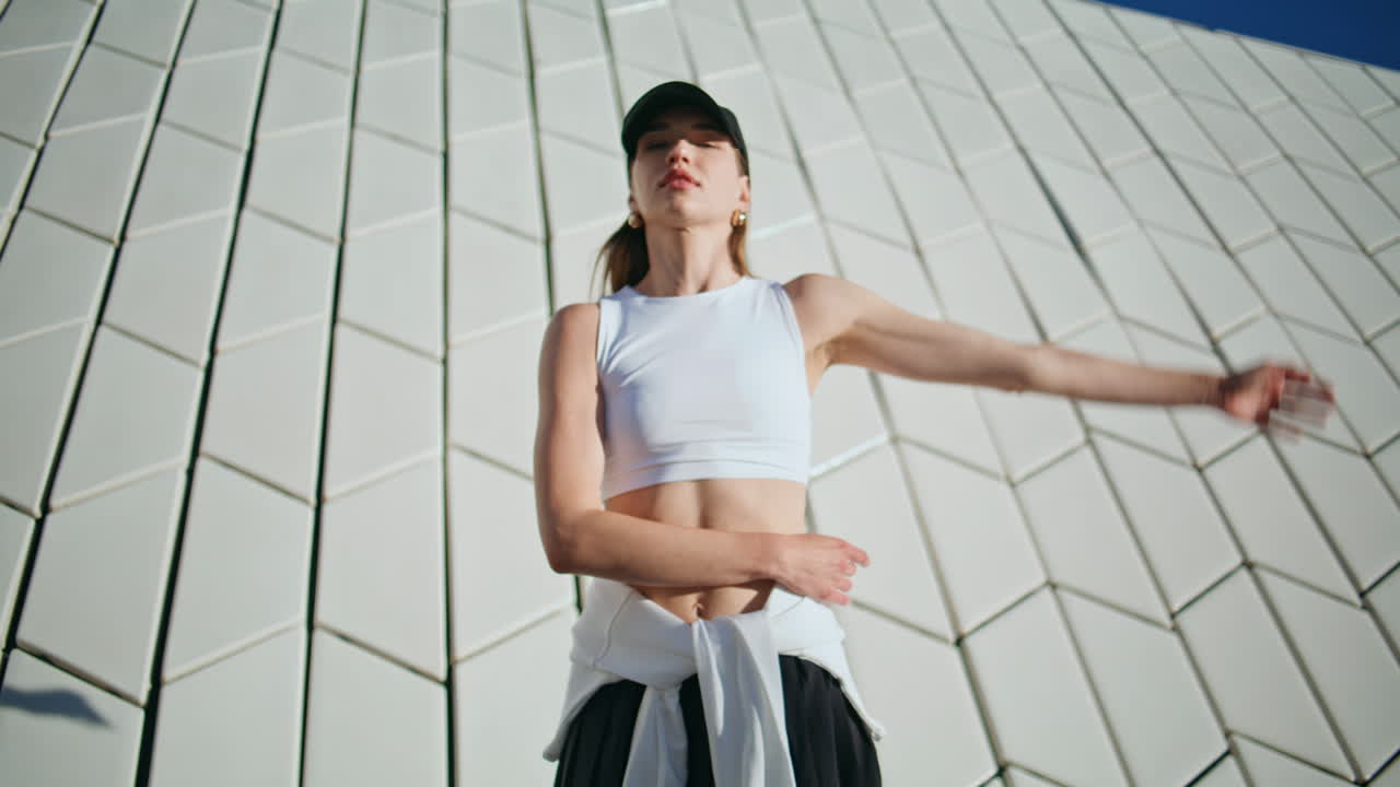 Athletic woman bending body practicing fitness exercises on sunny street closeup