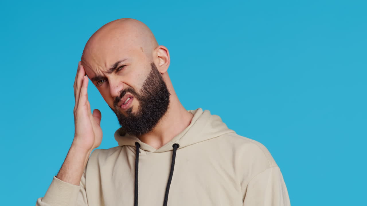 modelo árabe enfermo lidiando con un grave dolor de cabeza en el estudio