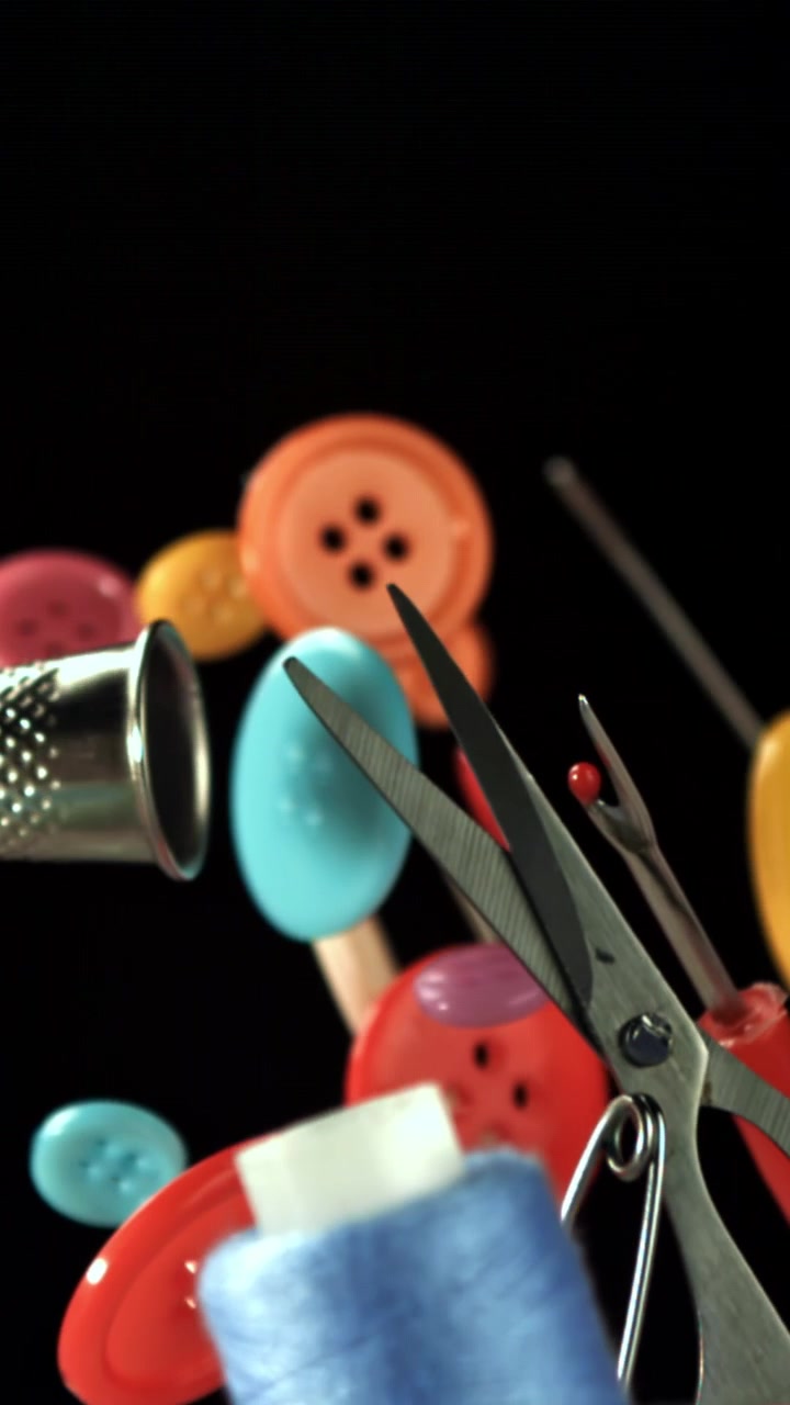 Colorful Sewing Supplies Falling in Slow Motion Against Black Background