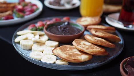 delicious turkish breakfast with pancakes, chocolate spread, and fruit