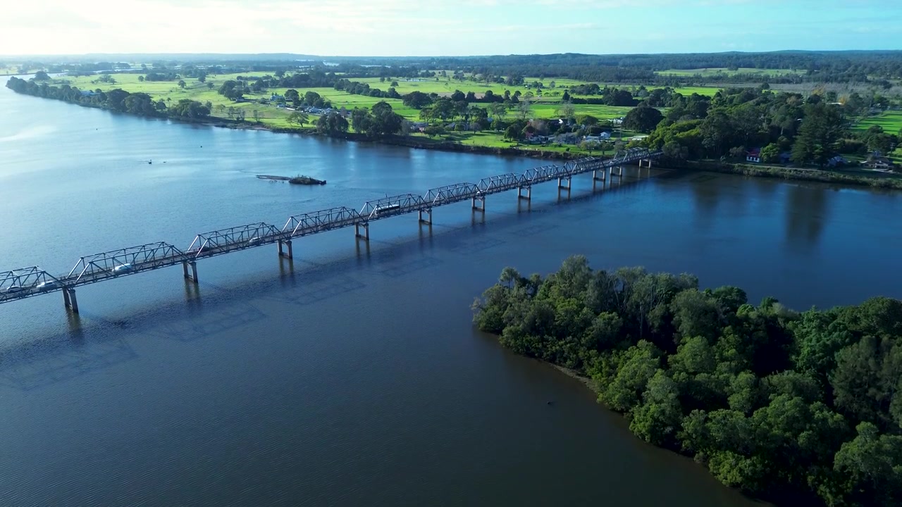 Paesaggio aereo con drone di veicoli che attraversano il ponte Martin sul fiume Manning, con la campagna rurale sullo sfondo, a Taree, Mid North Coast, Australia, infrastruttura
