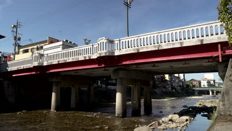 daytime picturesque scene unfolds as nakabashi bridge spans over the miyagawa river in takayama, japan