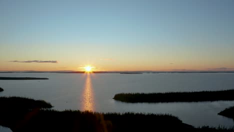 Toma-Aérea-De-Una-Puesta-De-Sol-Muy-Agradable-Sobre-Un-Lago-Vacío-Y-Salvaje-En-El-Norte-De-Canadá