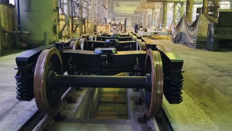 Construction-of-new-metal-wagons-for-train-wheels-in-large-factory,-upwards-pan