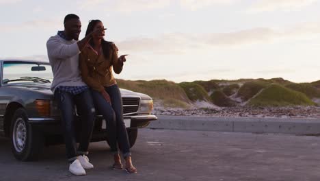 African-american-couple-pointing-towards-a-direction-while-standing-on-the-road