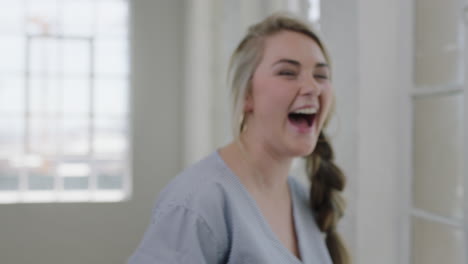 portrait of happy young blonde woman laughing excited in apartment home background enjoying fun