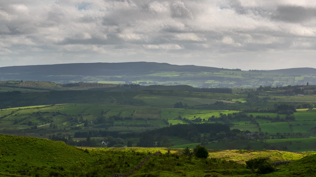 아일랜드에서 흐린 날 동안 풀밭과 언덕이 있는 시골 풍경의 시간 경과