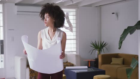 mujer de raza mixta mirando el diseño en la oficina creativa