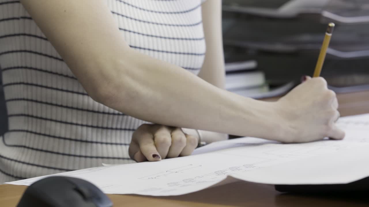 Woman working on blueprints in an office
