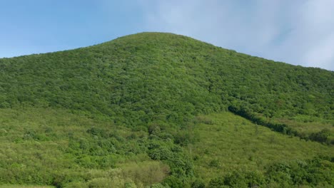 lush green hill and clear blue sky - aerial drone shot