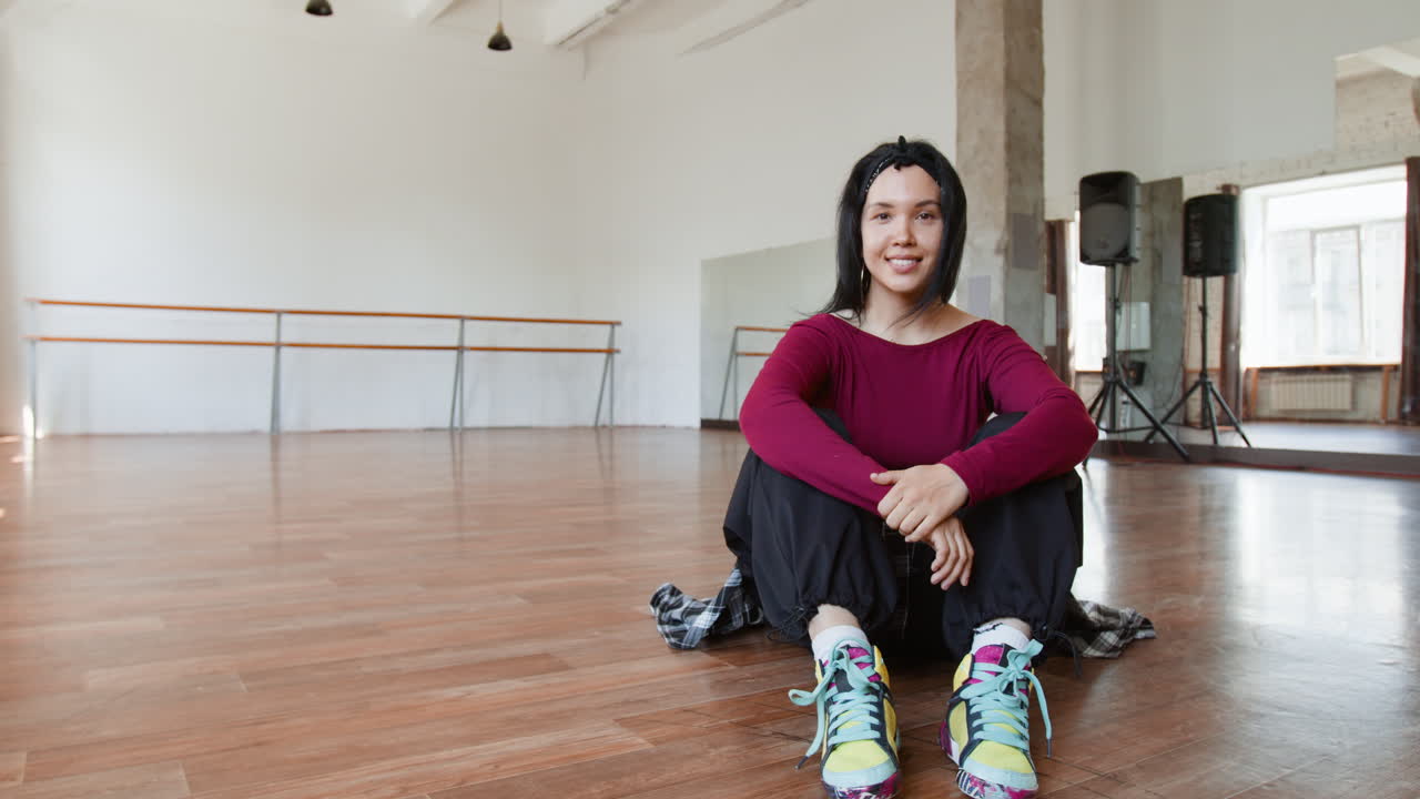Young Woman Relaxing in a Bright Dance Studio