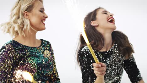 glamorous women with sparklers dancing in studio shot