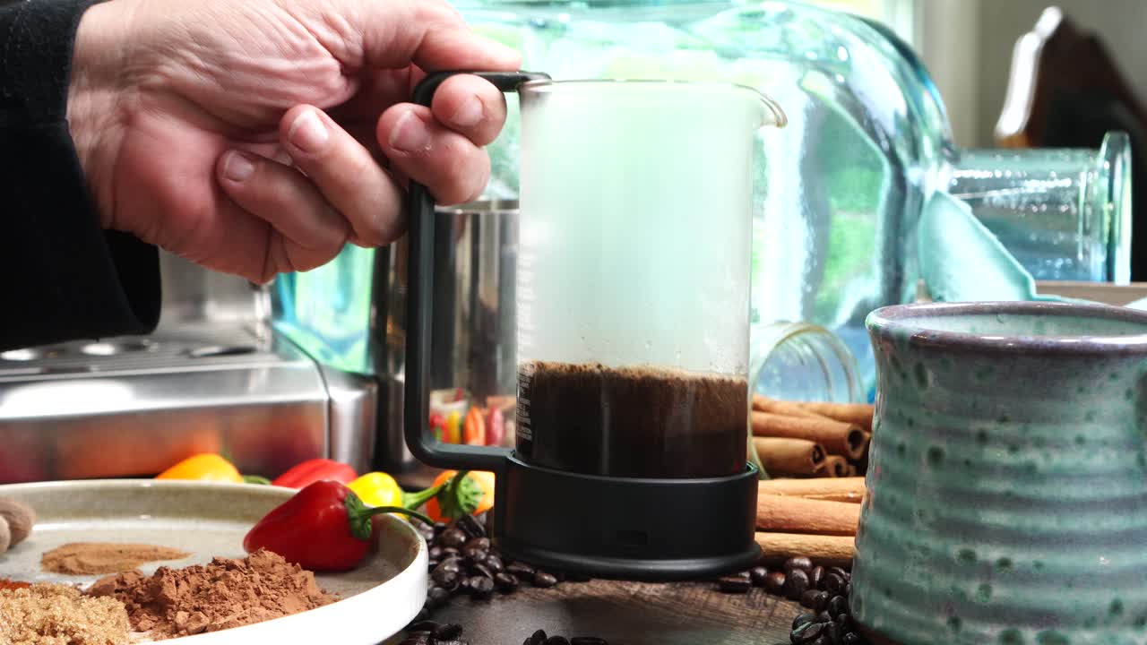 Cup or mug of coffee in a blue ceramic cup with whipped cream and a dash of nutmeg or cinnamon. Coffee beans surrounding a cozy cup of coffee in a blue mug.