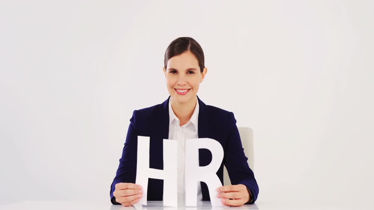 Businesswoman holding paper cut out of HR sign