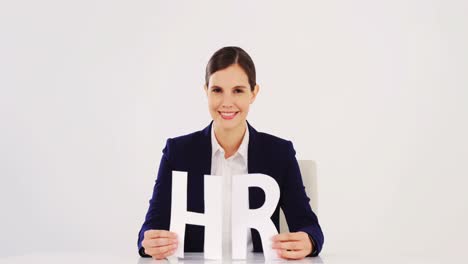 businesswoman holding paper cut out of hr sign
