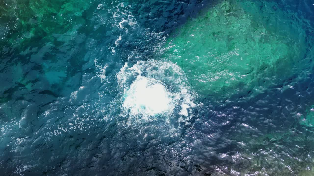 vista aérea de un turista masculino sin camisa saltando de un acantilado rocoso a las claras y turquesas aguas del océano en la isla tropical de catanduanes