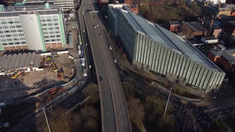 Vuelo-Aéreo-De-Drones-Sobre-El-Camino-Mancuniano-Que-Muestra-Los-Automóviles-Y-Los-Tejados-Debajo-En-El-Centro-De-La-Ciudad-De-Manchester,-Reino-Unido