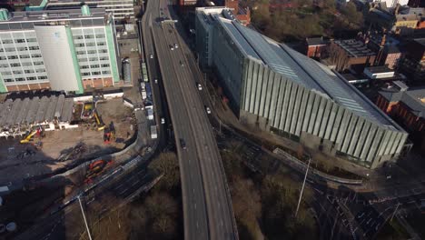 vuelo aéreo de drones sobre el camino mancuniano que muestra los automóviles y los tejados debajo en el centro de la ciudad de manchester, reino unido